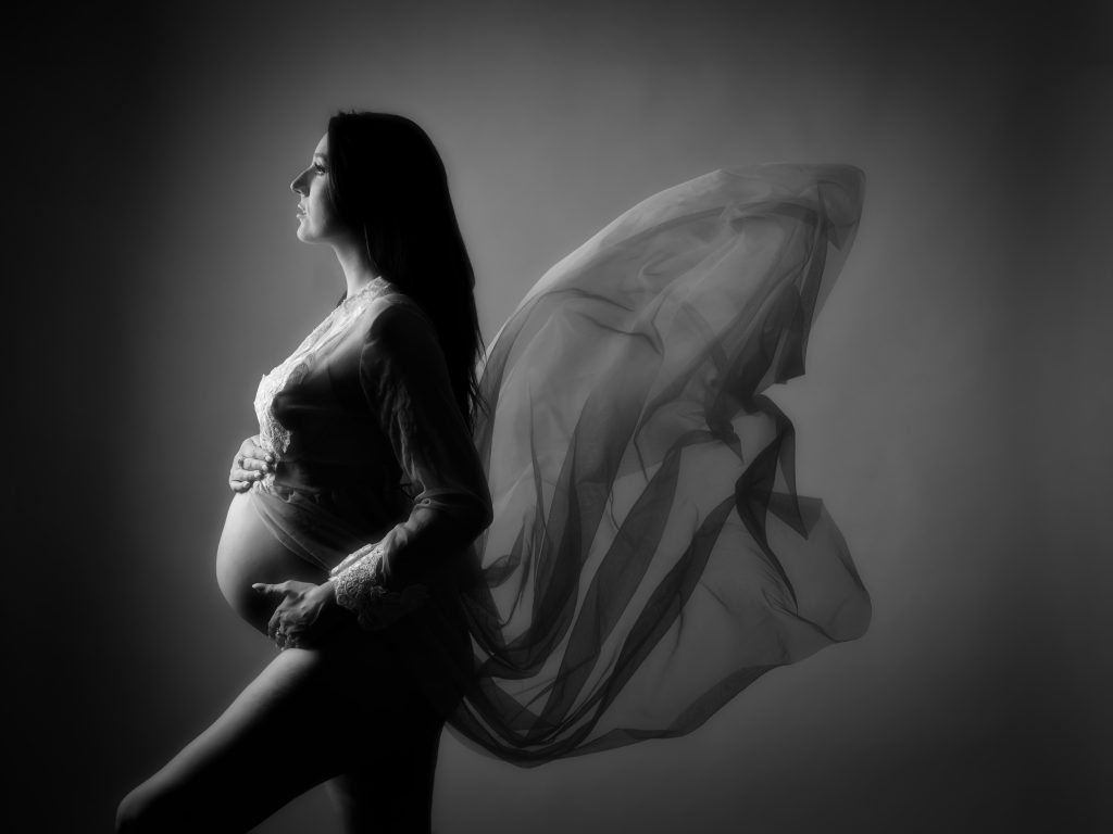 Beautiful black and white maternity photograph of woman holding pregnant bump