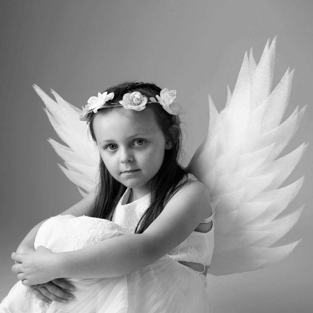 Little girls posing as an angel for The Angel Experience