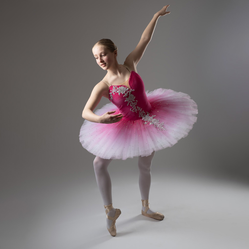 Photograph of a ballerina in a pink tutu striking a pose