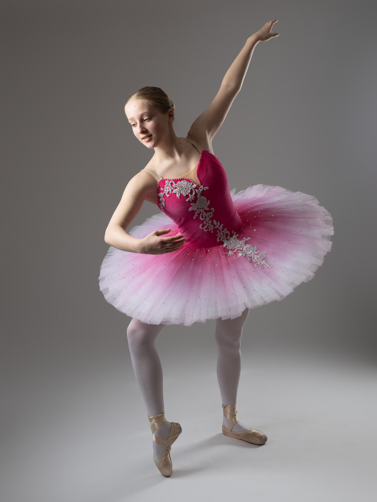 girl posing in pink tutu during a photoshoot.
