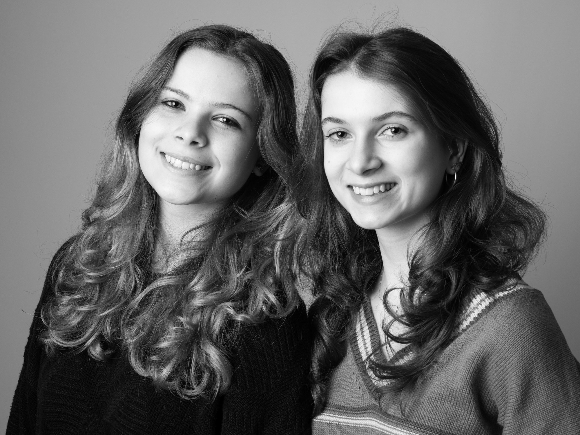 Two smiling teenage sisters, black and white