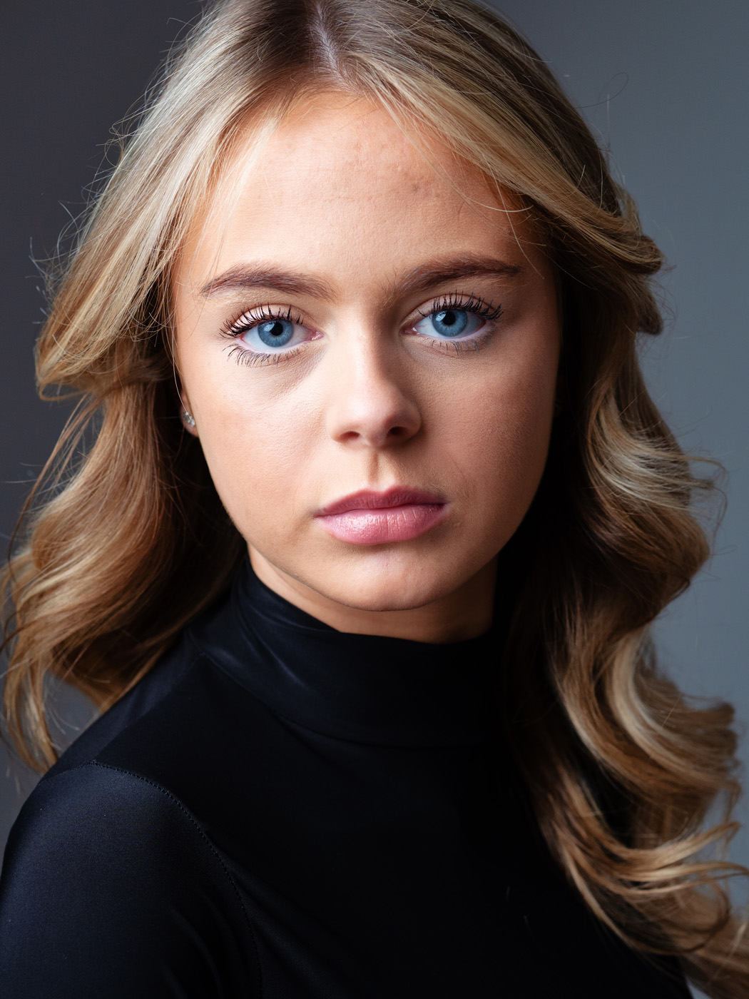 Colour headshot of a teenage girl with blue eyes and wavy hair