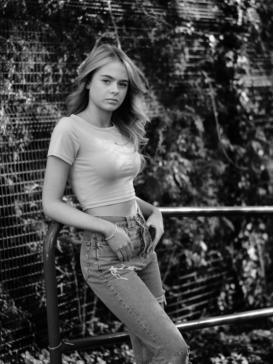 Teenage girl leaning on railings, black and white
