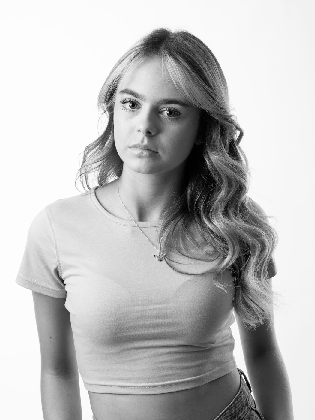 Teenage girl with long wavy hair on a white background, black and white