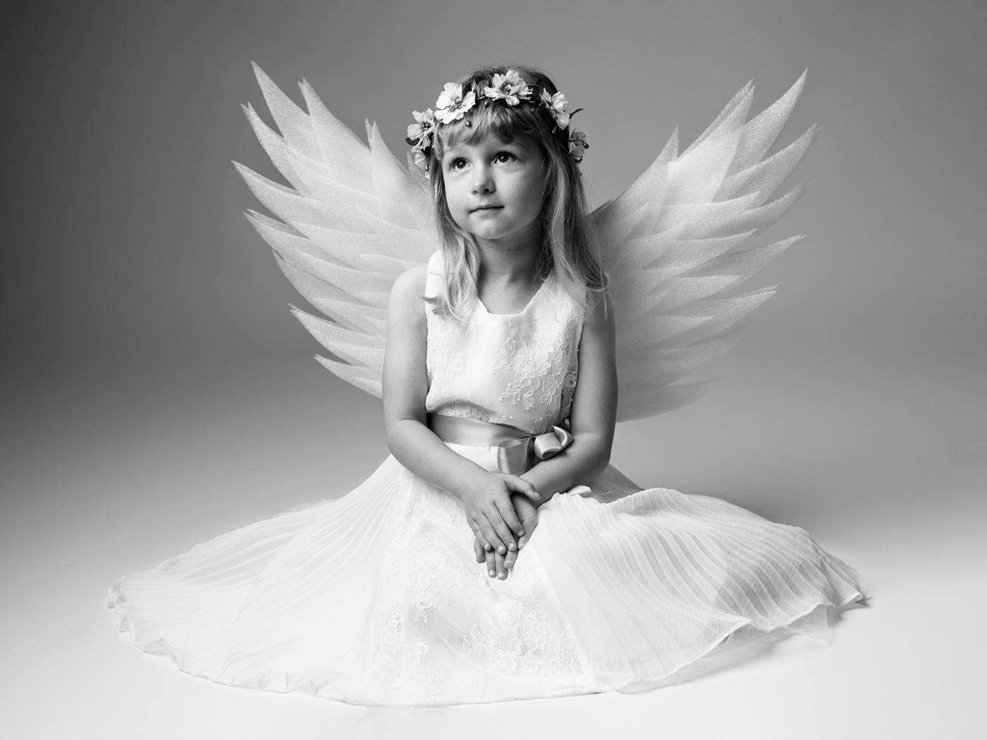 Little girl with angel wings and a flower crown, black and white