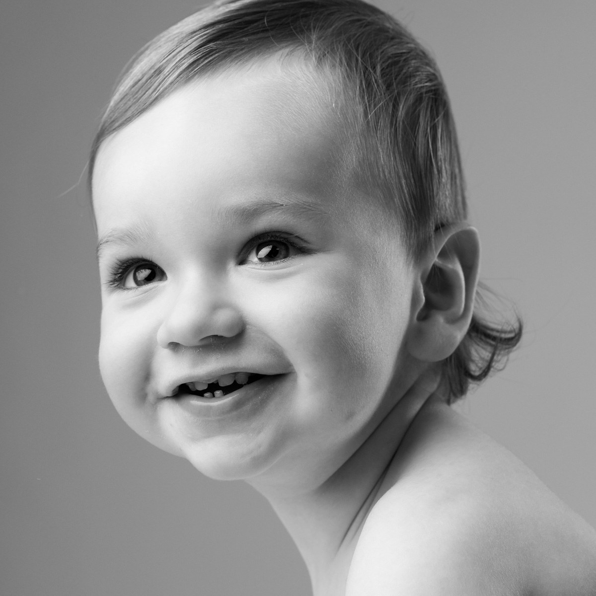 Baby smiling to the side, black and white