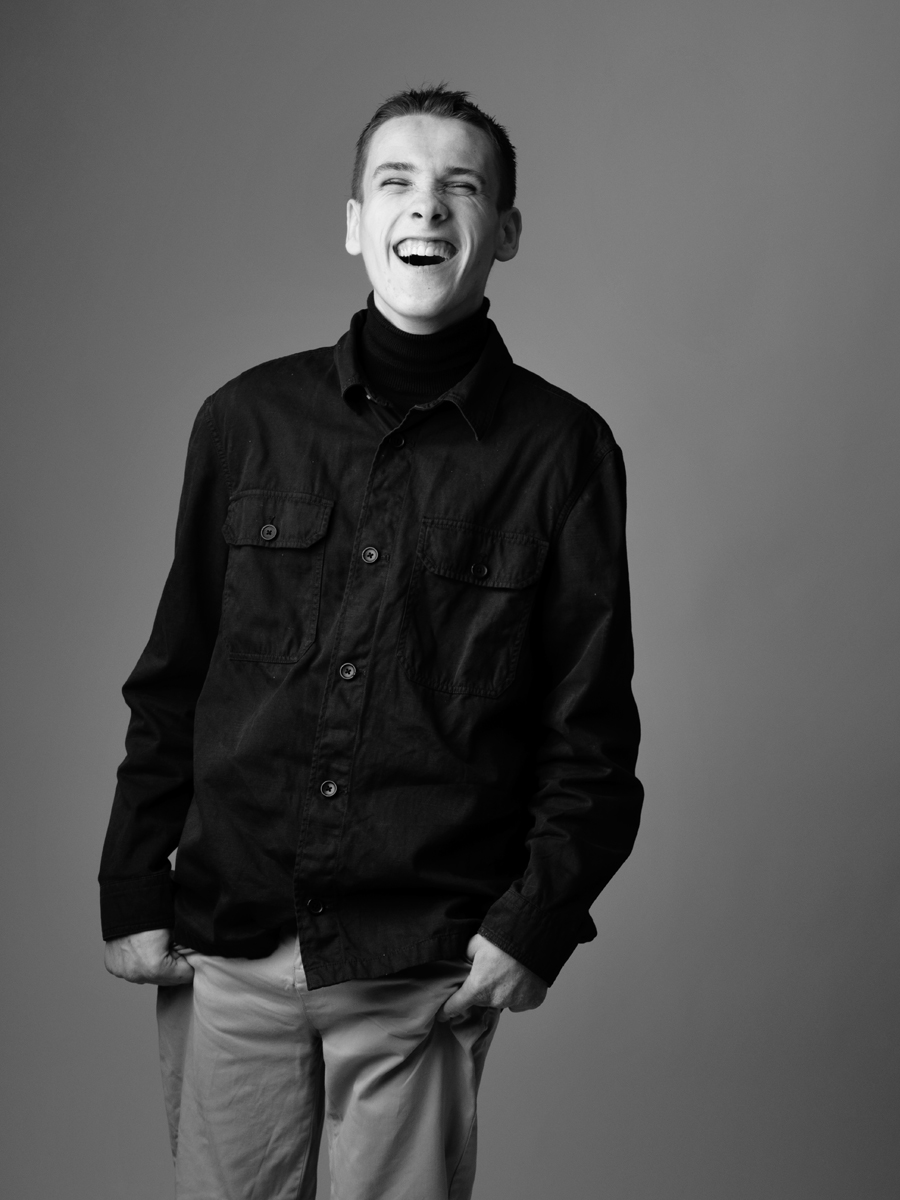 Laughing young man in a dark shirt, black and white