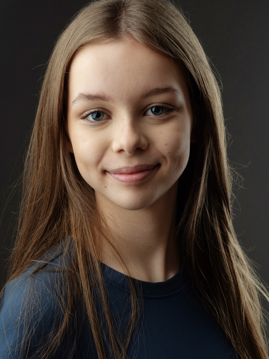 Colour headshot of a teenage actor on grey