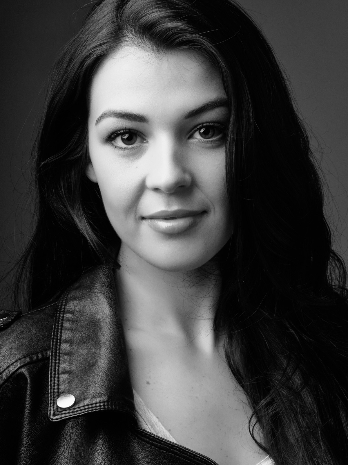 Black and white headshot of a woman in a leather jacket